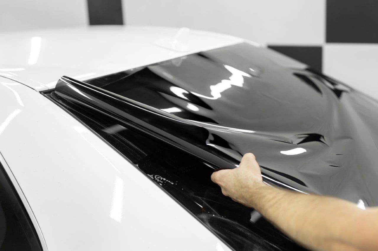 Tinting car window with black film.